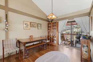 Dining room with lofted ceiling and hardwood / wood-style floors