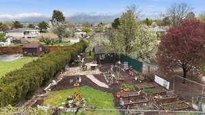 Fenced backyard with a garden, a storage unit, and a residential view