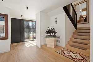 Entryway with stairway and light wood finished floors