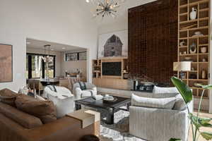 Living room with suspended lighting, a high ceiling, parquet flooring, and built in features