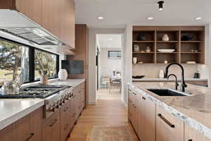 Kitchen featuring open shelves, stainless steel gas stovetop, light wood-type flooring, modern cabinets, and recessed lighting