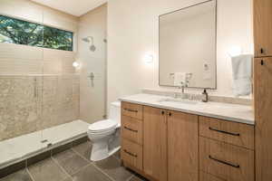 Bathroom featuring vanity, a stall shower, and dark tile patterned flooring