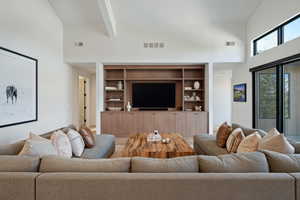 Living area featuring vaulted ceiling and built in features