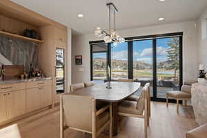 Dining space with light wood-style flooring, a residential view, and hanging lights