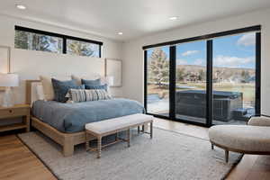Bedroom with light wood-style floors, access to exterior, and recessed lighting