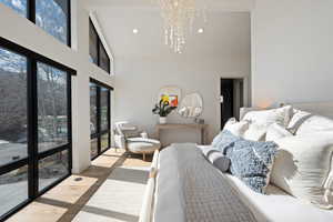 Bedroom featuring wood finished floors, suspended lighting, and vaulted ceiling