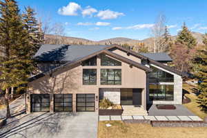Contemporary house featuring driveway, a mountain view, and an attached garage