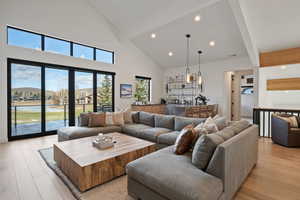 Living area featuring light wood-style flooring, recessed lighting, and vaulted ceiling