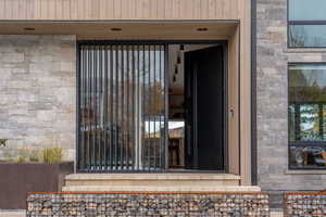 View of exterior entry featuring stone siding
