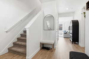 Hall featuring stairway and light wood finished floors