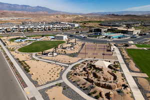 Aerial view of property and surrounding area featuring a mountain backdrop and nearby suburban area