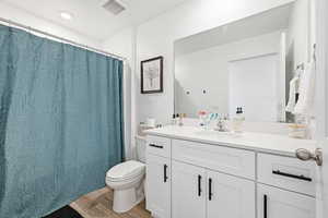 Bathroom with vanity, light wood finished floors, and shower / tub combo with curtain