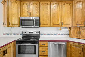 Kitchen featuring stainless steel appliances, backsplash, and light countertops