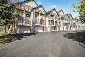 View of apartment community featuring driveway and an attached garage