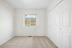 Bedroom 3 with light carpet and a closet