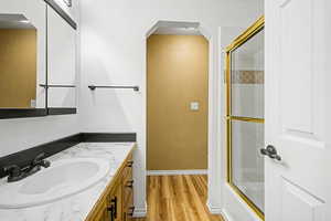 Master Bathroom with vanity, combined bath / shower with glass door, and light wood-style floors