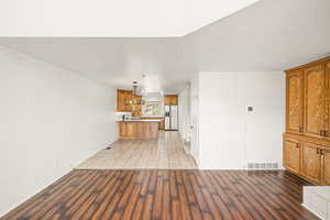 Unfurnished living room featuring dark wood-type flooring and baseboards