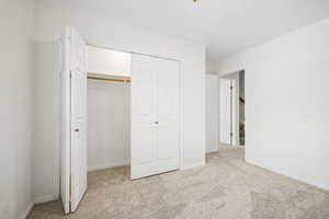 Bedroom 3 with light colored carpet and a closet