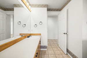 Powder/laundry room with vanity, light tile patterned floors, and washer and clothes dryer