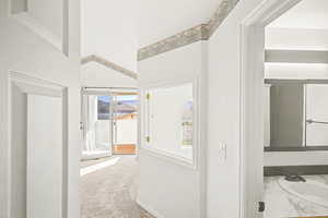 Hallway featuring light colored carpet and a sink
