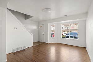Foyer entrance with dark wood-style floors and baseboards