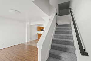 Stairs featuring wood finished floors and baseboards