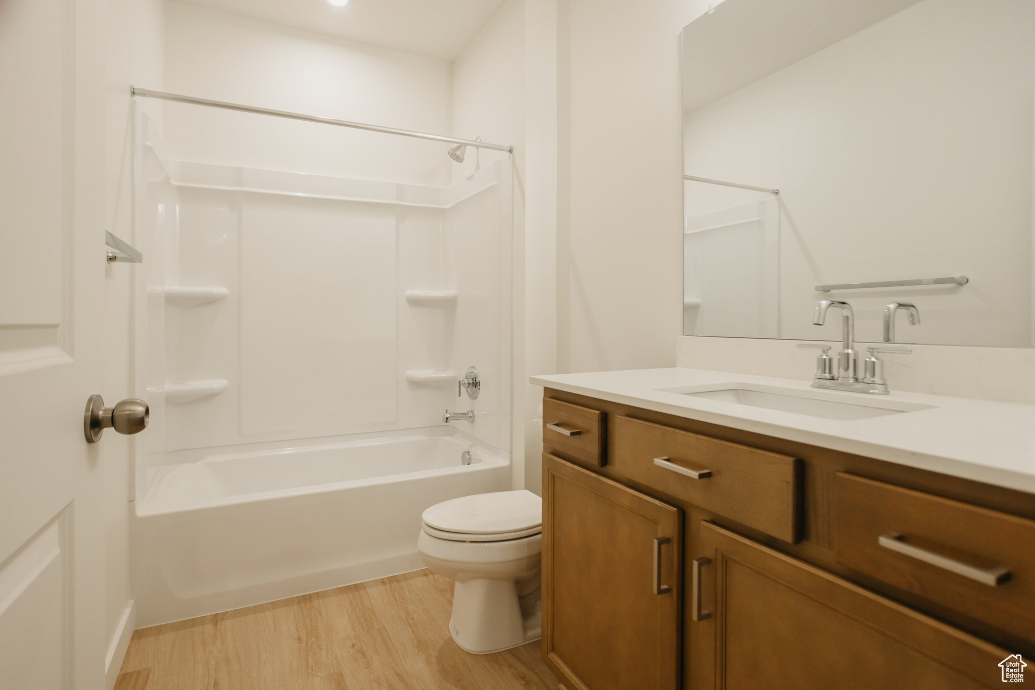 Example of basement of Bathroom with vanity, light wood finished floors, and shower / washtub combination