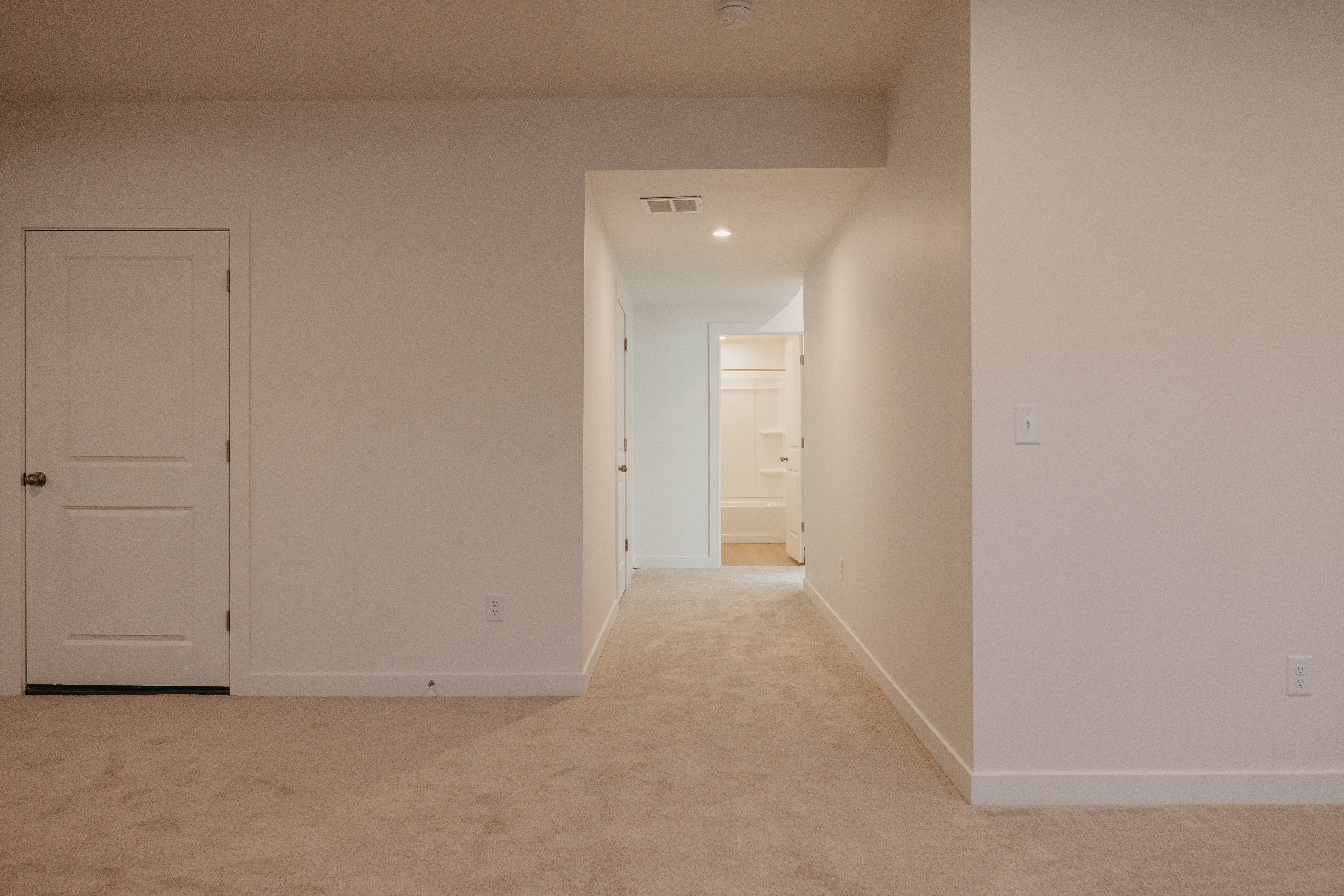 Example of basement - Corridor with light carpet and recessed lighting