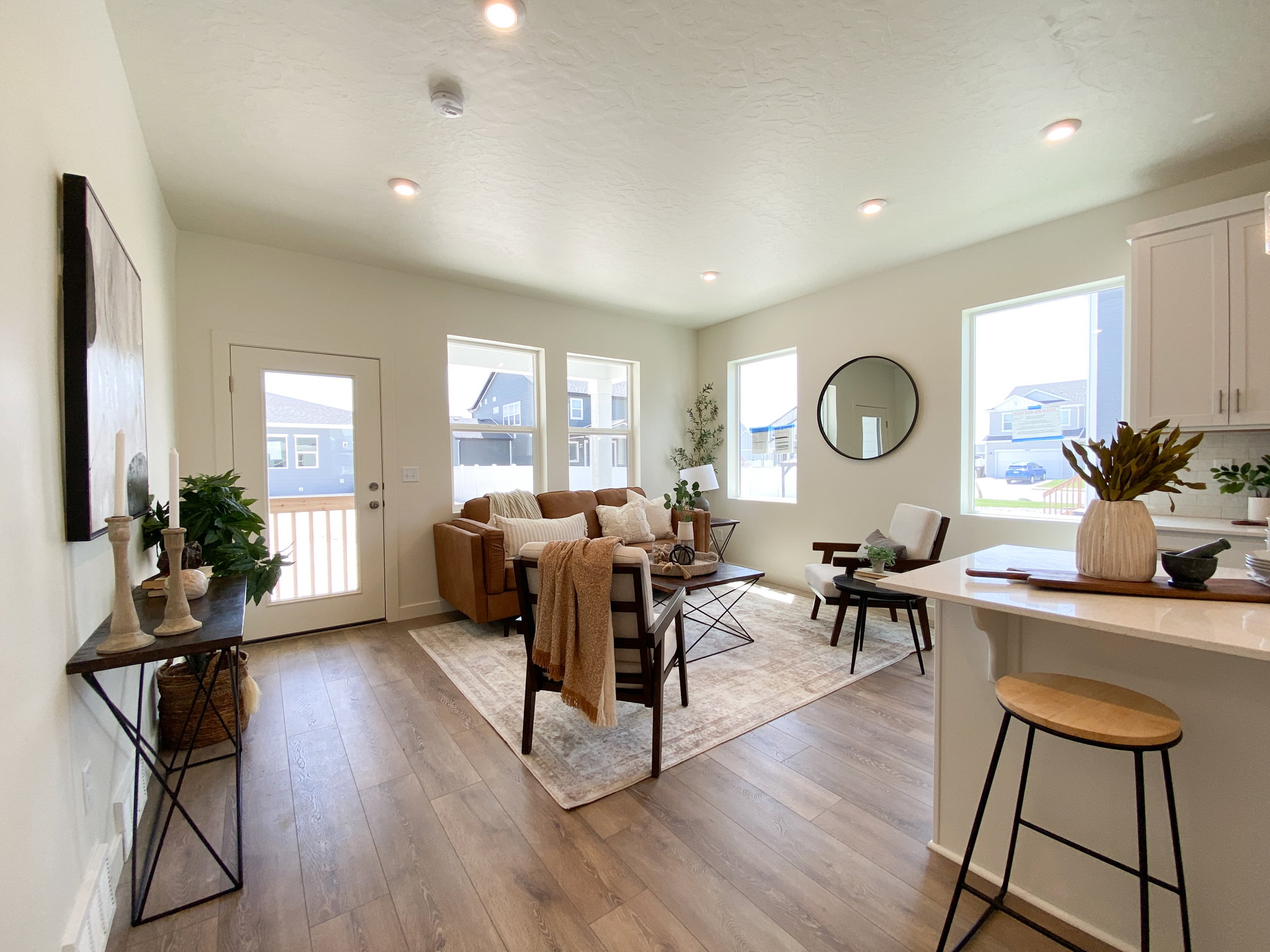 Example: Living room featuring light wood-style flooring, plenty of natural light, and recessed lighting