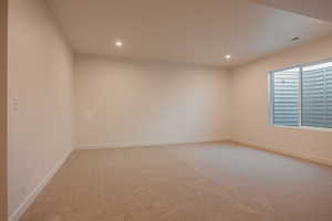 Example of basement - Unfurnished room featuring light colored carpet and recessed lighting