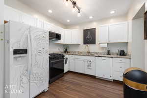 Kitchen with white appliances, dark wood-type flooring, light stone counters, white cabinetry, and recessed lighting