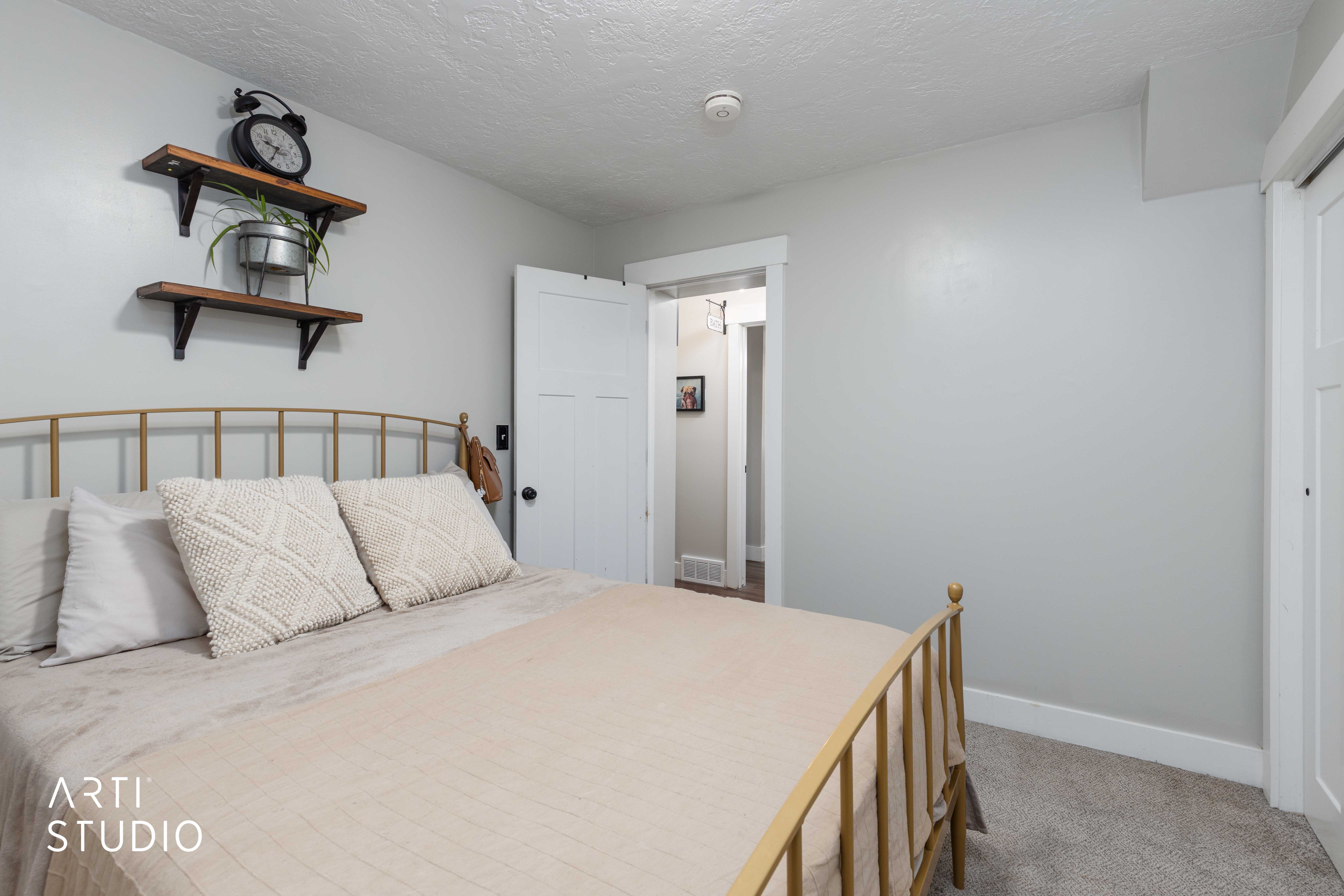 Bedroom with light colored carpet and a textured ceiling