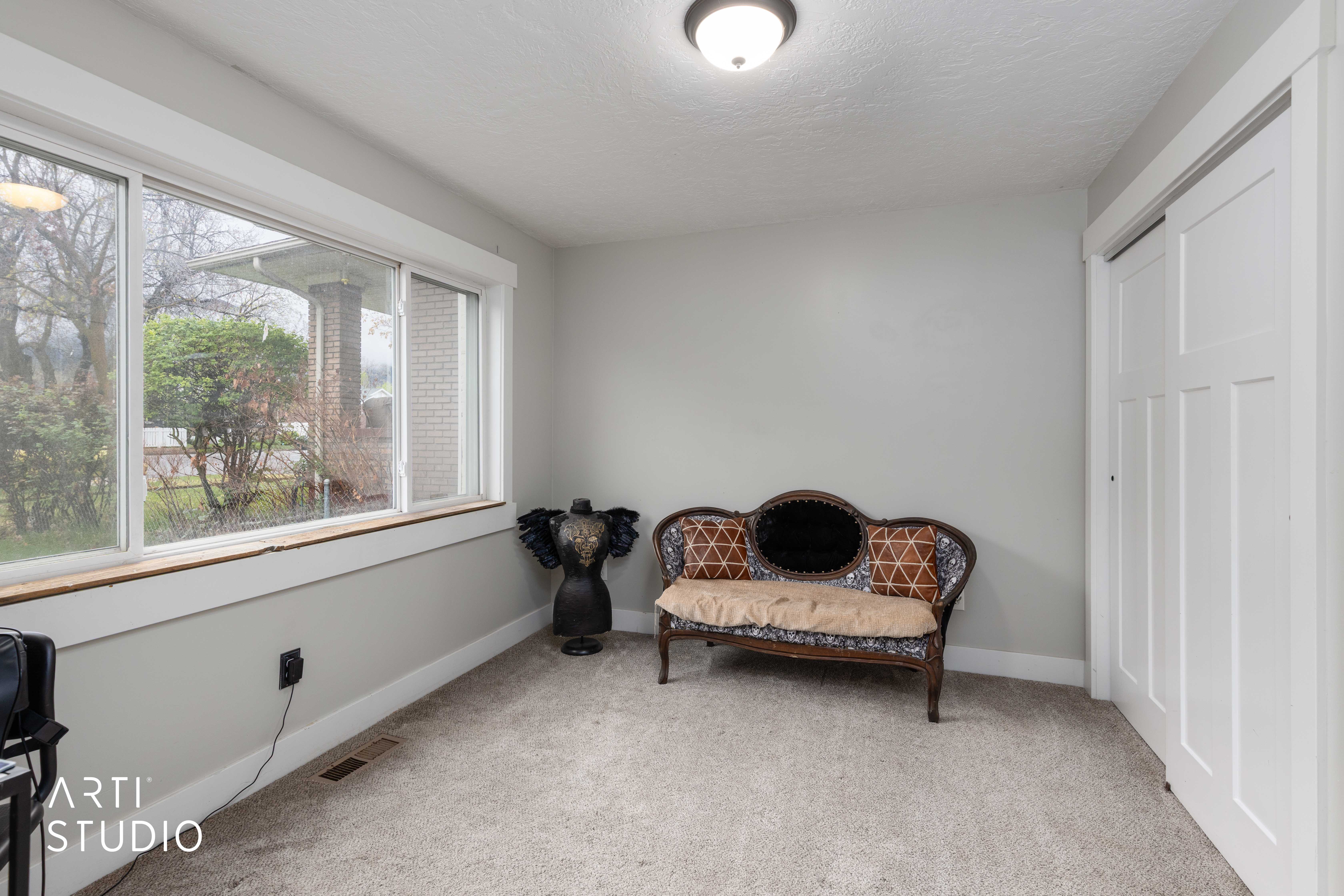 Sitting room with light colored carpet and a textured ceiling