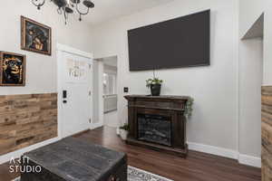 Foyer with dark wood-style floors and baseboards