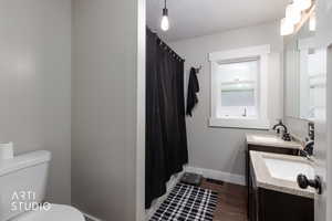 Bathroom featuring two vanities and dark wood finished floors