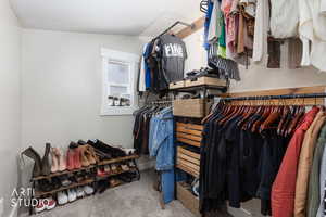 Walk in closet with light colored carpet