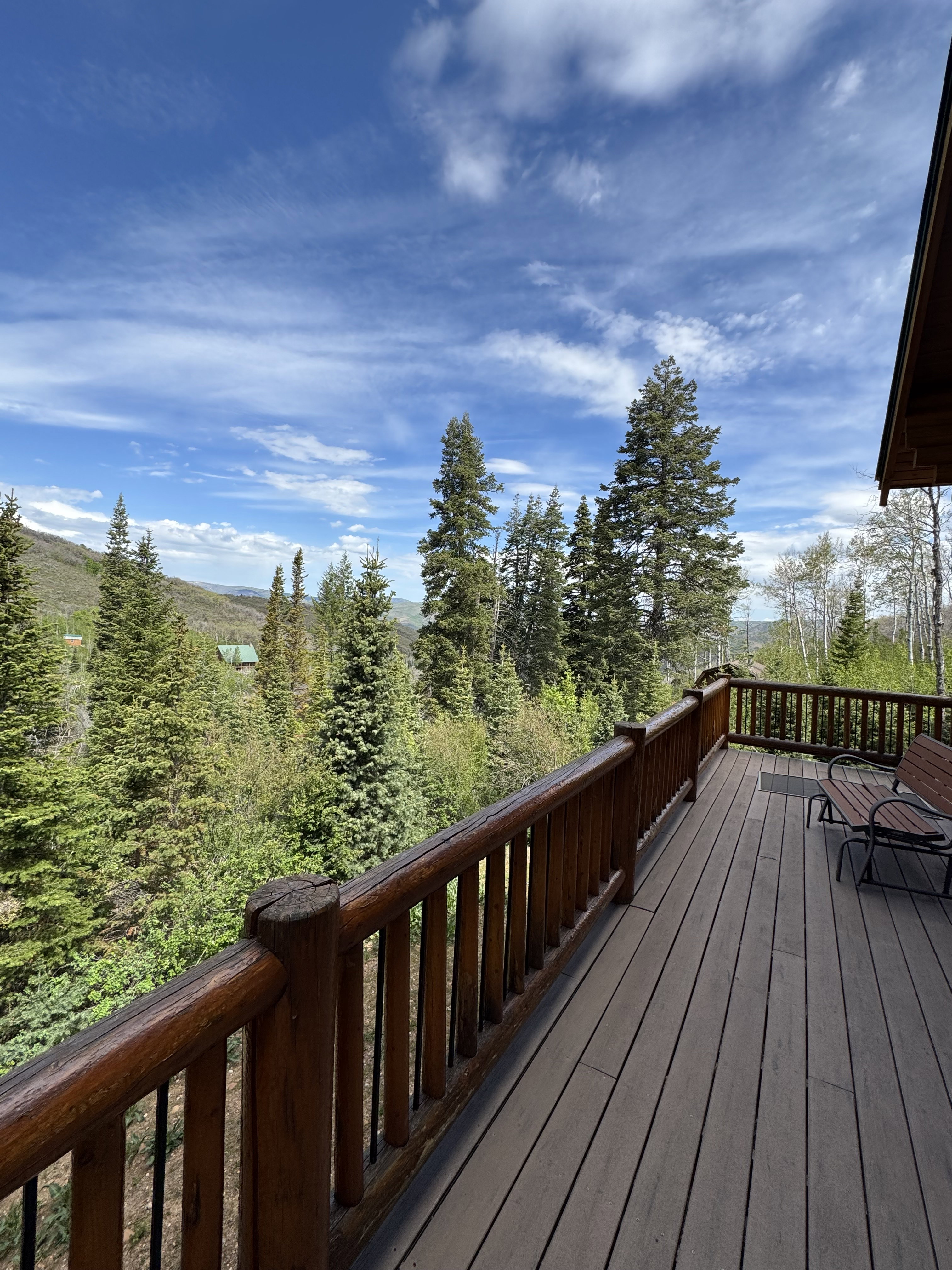 Spacious outdoor deck featuring wood-finish decking and rustic log railing