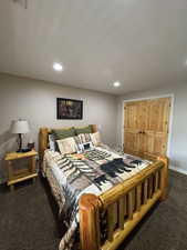 Bedroom featuring dark carpet, a closet, and recessed lighting