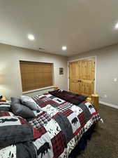 Bedroom with dark colored carpet and recessed lighting
