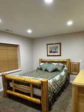 Bedroom with dark carpet and recessed lighting