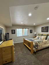 Bedroom with dark carpet, a textured ceiling, and recessed lighting