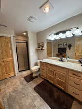 Full bath with vanity, a stall shower, a textured ceiling, and light tile patterned flooring