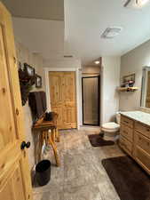 Full bath featuring a shower stall, a textured ceiling, vanity, and heated floor