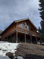 View of home's exterior with a deck and stone