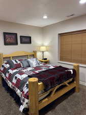 Bedroom with dark colored carpet and recessed lighting
