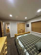 Bedroom featuring dark carpet and recessed lighting