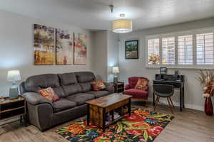 Living room featuring a textured ceiling and light wood finished floors