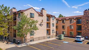 View of apartment building / complex with uncovered parking