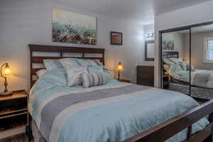 Bedroom featuring a textured ceiling, a textured wall, and a closet