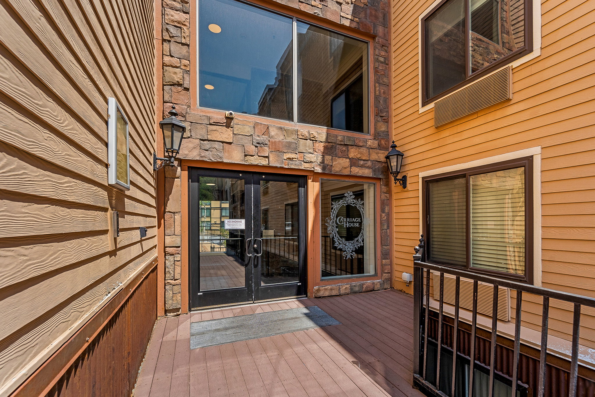 Entrance to property with a deck and stone siding